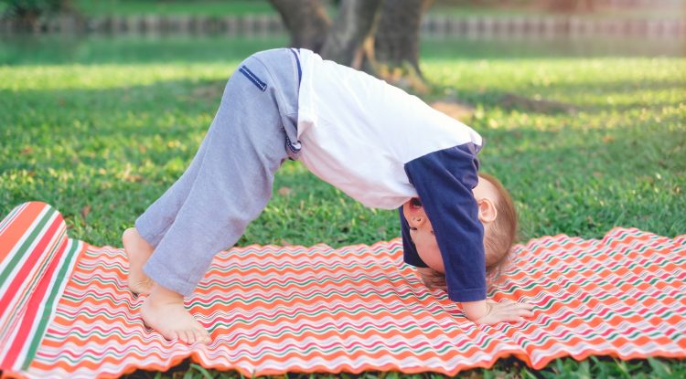 Little boy doing yoga outdoors
