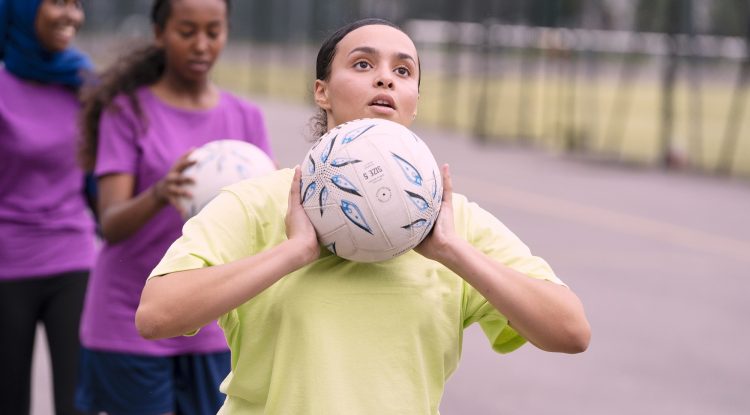 young girl playing netball