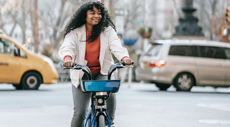 smiling young woman on bike in city